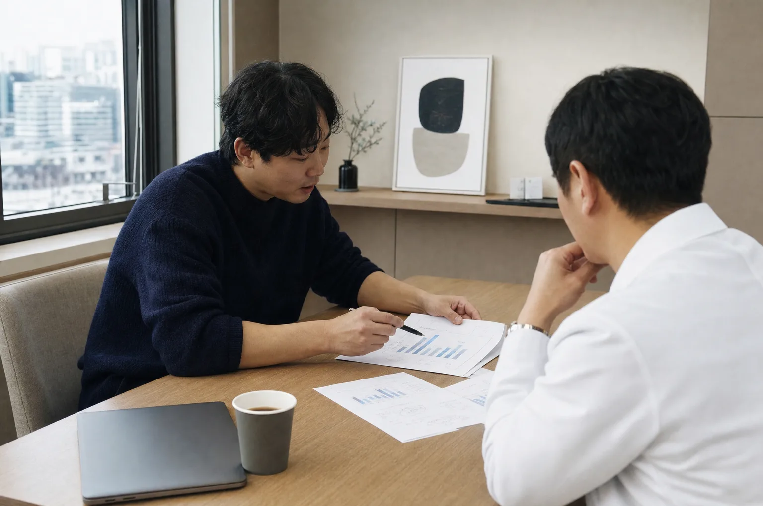 회의 테이블에서 두 사람이 막대그래프가 있는 출력 리포트를 함께 검토하는 모습